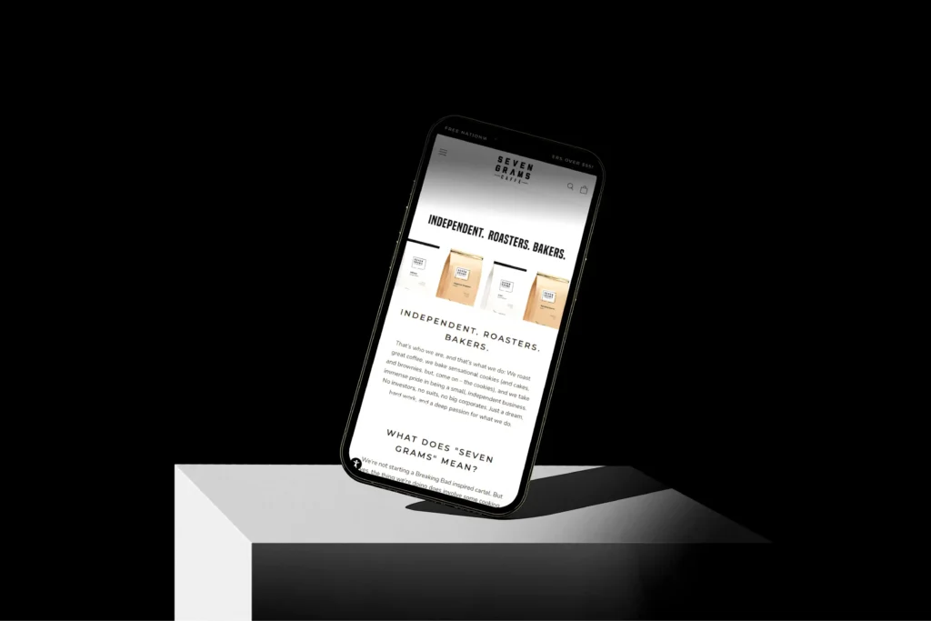 Minimal black-and-white mobile website mockup displayed on a tilted smartphone screen.