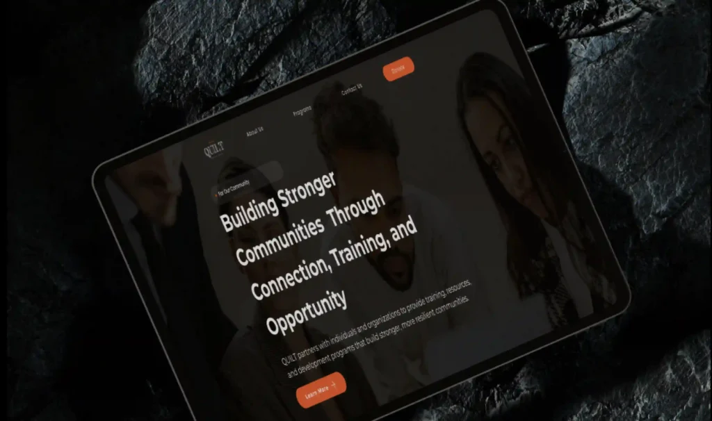 Tablet mockup showcasing the QUILT nonprofit website homepage with a modern dark-themed interface focused on community connection, training, and opportunity.